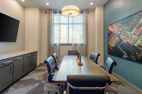 Atlanta apartment for rent - a conference room with a long table and chairs and a large painting on the wall