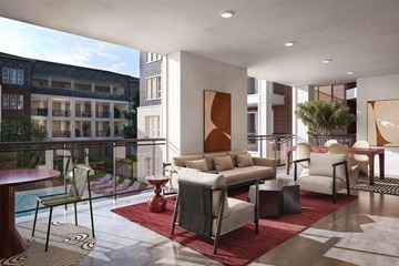 Austin apartment for rent - A modern living room with a pool table and a balcony overlooking a building.