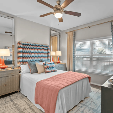 Montgomery apartment for rent - A bedroom with a bed, a ceiling fan, and a dresser with a mirror.