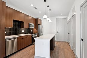 Lewisville apartment for rent - A modern kitchen with wooden cabinets and a white island.