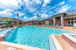 Katy apartment for rent - A large swimming pool with a blue tiled edge and a white line down the middle.