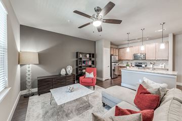 Katy apartment for rent - A living room with a red chair and a white couch.