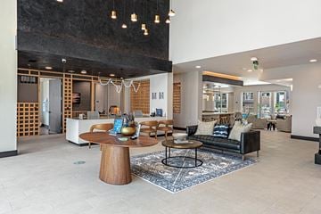 Plano apartment for rent - A modern living room with a wooden coffee table and a black couch.