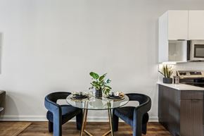 Nashville apartment for rent - A modern dining area with a glass table and blue chairs.