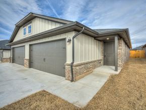 Oklahoma City triplex for rent - a home with two garage doors and a concrete driveway