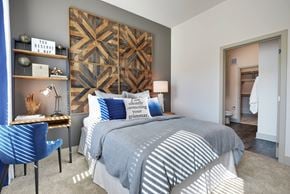 Farmers Branch apartment for rent - A bedroom with a large bed and a blue chair.