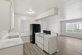 Stephenville apartment for rent - A kitchen with a black refrigerator, white countertops, and wooden flooring.