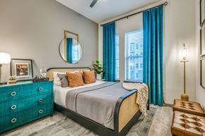 Farmers Branch apartment for rent - A bedroom with a bed, dresser, and mirror.