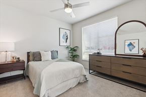 Denver apartment for rent - A bedroom with a bed, dresser, and mirror.
