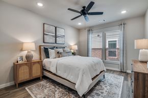 Lavon apartment for rent - A bedroom with a bed, nightstands, and a ceiling fan.