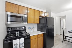 Stephenville apartment for rent - A kitchen with a black refrigerator and stove.