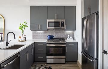 Houston apartment for rent - a kitchen with stainless steel appliances and black cabinets