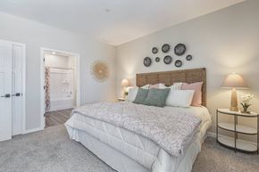Crystal Lake apartment for rent - A bedroom with a large bed and a nightstand with a lamp.