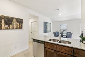 Harker Heights townhouse for rent - A kitchen with a large painting on the wall and a dishwasher in the middle.