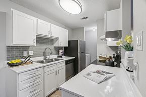 Austin apartment for rent - A kitchen with white cabinets and a white countertop.