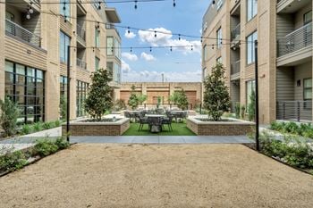 Entertaining courtyard featuring café seating and covered entertainment area equipped with corn hole games, lounge seating and tvs