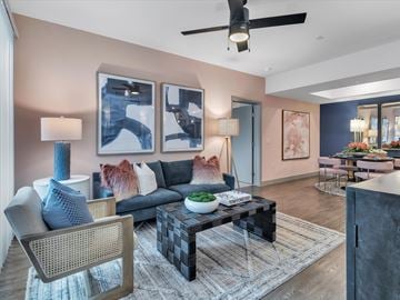 Las Vegas apartment for rent - A modern living room with a black and white coffee table, a grey sofa, a blue chair, and a painting on the wall.