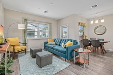 Fort Myers apartment for rent - a living room with a blue couch and a dining room table