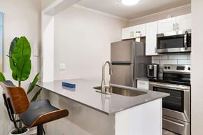 Dallas apartment for rent - a kitchen with white cabinets and stainless steel appliances