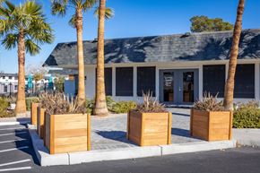 Las Vegas apartment for rent - a building with a gray roof and palm trees in front of it