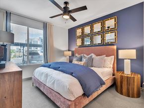 Las Vegas apartment for rent - A bedroom with a bed, a ceiling fan, and a window with blinds.