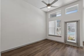Katy apartment for rent - A room with a ceiling fan and a door leading to a balcony.