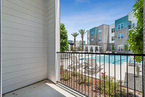 Katy apartment for rent - A balcony with a pool and apartment buildings in the background.