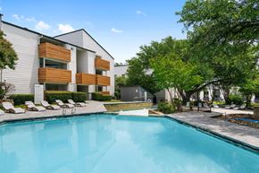Dallas apartment for rent - a swimming pool in front of a building with a resort style pool