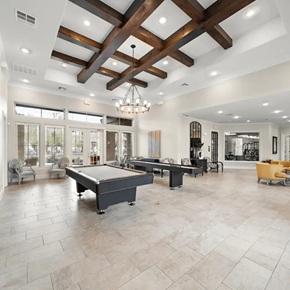 Montgomery apartment for rent - A large billiard table is in the middle of a spacious room with a high ceiling and wooden beams.