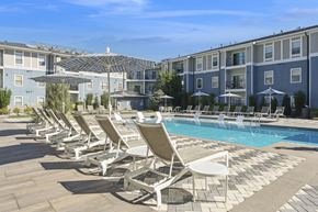 Lone Tree apartment for rent - A row of sun loungers are set up by a pool.