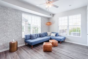 Cincinnati apartment for rent - A living room with a blue couch and a ceiling fan.