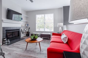 Cincinnati apartment for rent - A living room with a red couch and a fireplace.