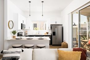 Prescott Valley apartment for rent - A modern kitchen with a breakfast bar and a white couch with pillows.