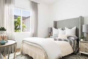 Prescott Valley apartment for rent - A bedroom with a large bed and a round table with a vase on it.