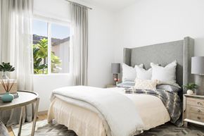 Prescott Valley apartment for rent - A bedroom with a large bed and a round table with a vase on it.