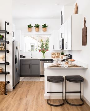 Phoenix apartment for rent - a kitchen with white cabinets and a counter with two stools