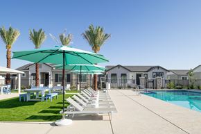 Maricopa apartment for rent - a pool with lounge chairs and umbrellas in front of a house
