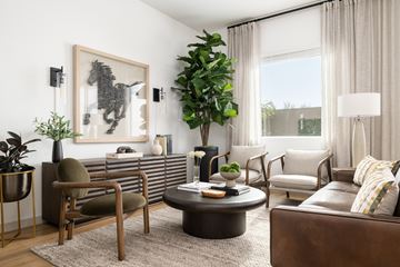 Omaha townhouse for rent - A living room with a brown leather couch, a coffee table, and a large painting on the wall.