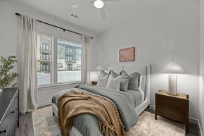 Buda apartment for rent - A bedroom with a bed, a nightstand, and a window with curtains.
