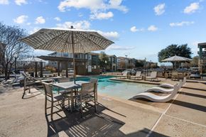 San Marcos apartment for rent - A sunny day at the pool with chairs and an umbrella.