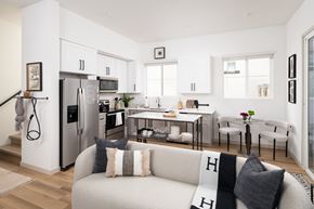 Casa Grande townhouse for rent - A modern kitchen with a refrigerator, a dining table with chairs, and a sofa with cushions.