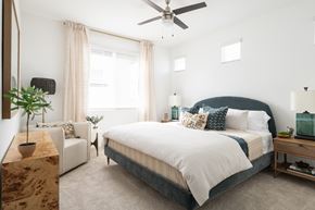 Casa Grande townhouse for rent - A bedroom with a large bed and a ceiling fan.