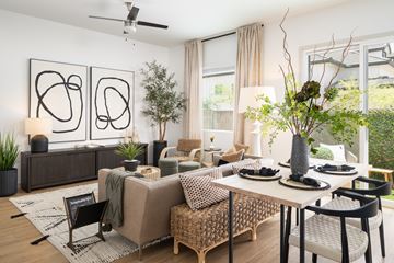 Phoenix apartment for rent - A modern living room with a brown sofa, a wooden coffee table, and a large abstract painting on the wall.