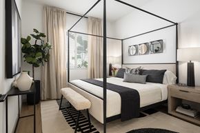 Litchfield Park apartment for rent - A modern bedroom with a four poster bed and a plant on the side table.