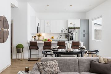 Queen Creek apartment for rent - A modern living room with a grey couch and a kitchen in the background.