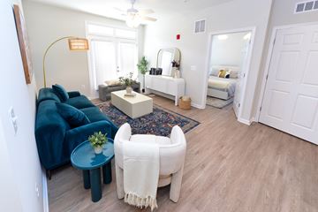 Woodbridge apartment for rent - A living room with a blue couch and a white chair.