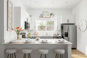 Surprise apartment for rent - A modern kitchen with a white color scheme and a large island in the center.