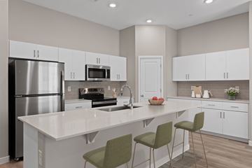 Phoenix apartment for rent - A modern kitchen with white cabinets and a central island.