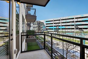 Lewisville apartment for rent - A balcony with a view of a pool and buildings.