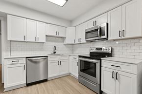 Durham apartment for rent - a white kitchen with stainless steel appliances and white cabinets